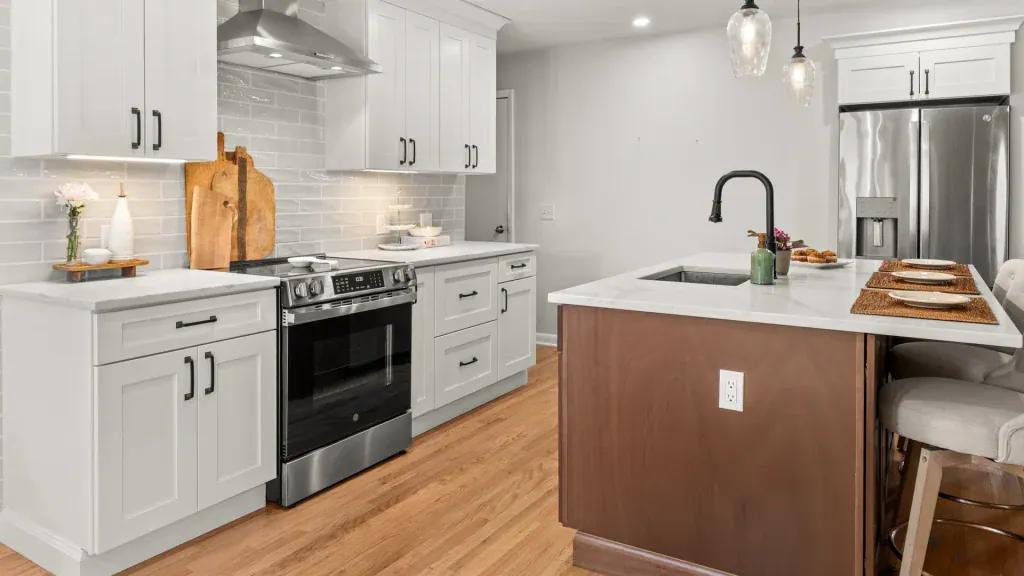Rift-sawn white oak island facing white cabinetry, quartz counters, and the stainless steel range.